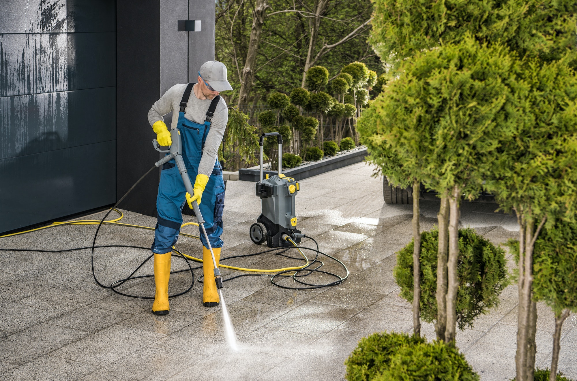 Cleaning His Modern House Surroundings with a Powerful Pressure Washer. Cleaning His Modern House Surroundings with a Powerful Pressure Washer.